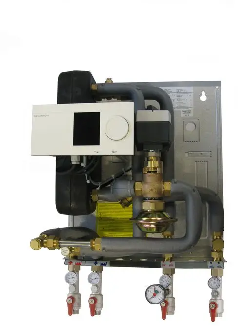 Hausstation mit integrierter Regelung von Danfoss, bestehend aus Rohren, Ventilen und Druckanzeigen. Keine Pumpe sichtbar, zur Installation an der Wand geeignet.